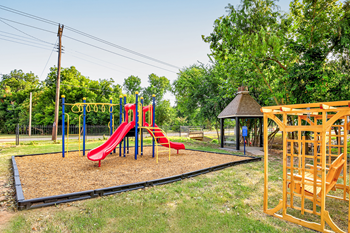 a playground at a park with a red slide at Diamond  Trail Apartments, Oklahoma City, OK